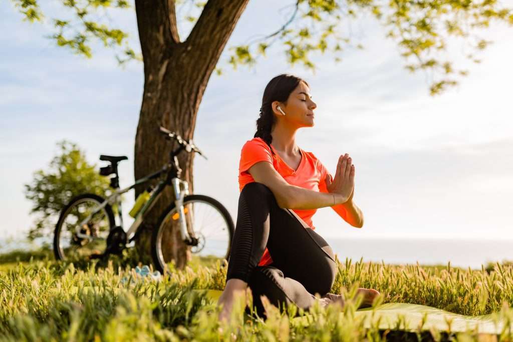 Woman doing yoga in the park in the morning